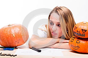 Halloween concept, happy Girl sitting at table with pumpkins pre