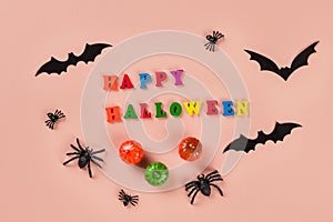 Halloween concept with multi-colored wooden words Happy Halloween on pastel beige background. Holiday decorations: pumpkins, bats