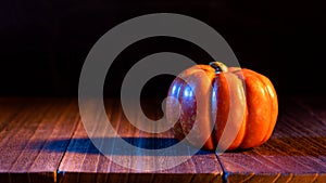 Halloween concept - Orange pumpkin lantern on a dark wooden table with black background, trick or treat, close up