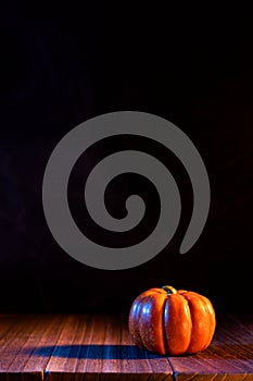 Halloween concept - Orange pumpkin lantern on a dark wooden table with black background, trick or treat, close up