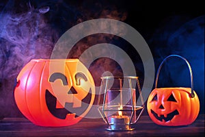 Halloween concept - Orange pumpkin lantern on a dark wooden table with double colored smoke around the background, trick or treat