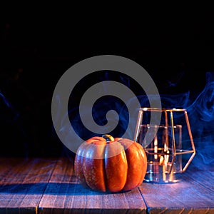 Halloween concept - Orange pumpkin lantern on a dark wooden table with double colored smoke around the background, trick or treat