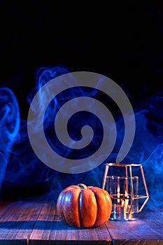 Halloween concept - Orange pumpkin lantern on a dark wooden table with double colored smoke around the background, trick or treat