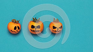 Halloween concept. Three scary pumpkins on an azure background with space for text, flat style