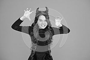 Halloween costumes designed after supernatural figures. Little devil. Little girl red horns celebrate Halloween