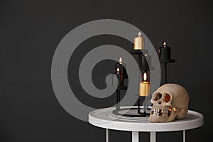 Halloween decor on table near black wall. Idea for festive interior