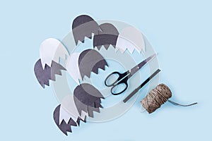 Halloween decorarion. Concept DIY and children creativity. Step-by-step instructions: make ghosts from white and black paper. Step photo
