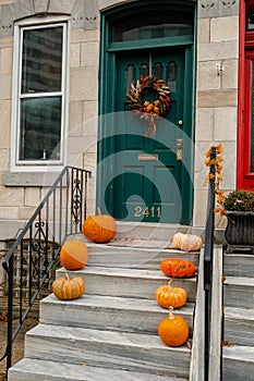 Halloween decorated front door with various size and shape pumpkins