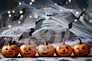 Halloween decoration with funny pumpkin heads, spider, web and flying bat on mystical background.