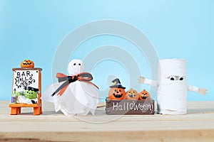 Halloween decoration with ghosts on table and blue background