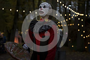 Halloween decoration, grinning clown standing on ghosts background