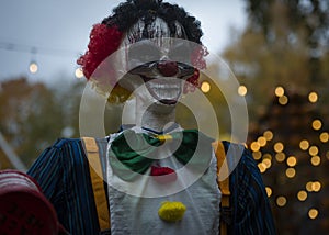 Halloween decoration, grinning clown standing on ghosts background