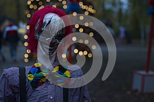 Halloween decoration, grinning clown standing on ghosts background