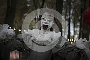 Halloween decoration, grinning clown standing on ghosts background