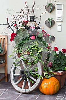 Halloween decoration - pumpkin, Scarecrow, old wooden wheel near the door