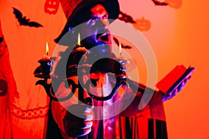 Halloween decoration and scary concept. Man pronounces a spell, reads a magic book. Halloween background. 31 october.