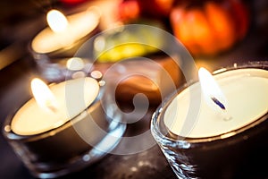 Halloween Decoration With Three Candlelights, Chocolate And Pumpkins On Slate