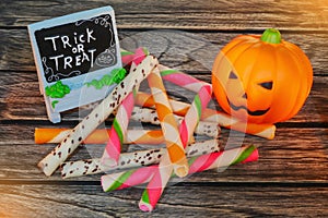 Halloween decoration trick or treat , jack-o-lantern pumpkin with snack on wooden background