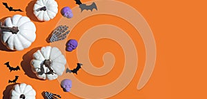 Halloween decorations bats, pumpkins and skulls on color background. Halloween concept. Flat lay, top view, copy space