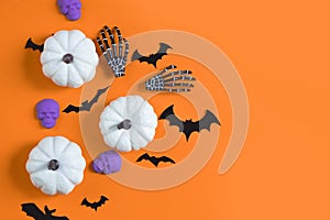 Halloween decorations bats, pumpkins and skulls on color background. Halloween concept. Flat lay, top view, copy space