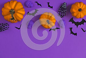 Halloween decorations bats, pumpkins and skulls on color background. Halloween concept. Flat lay, top view, copy space