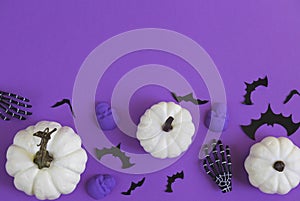 Halloween decorations bats, pumpkins and skulls on color background. Halloween concept. Flat lay, top view, copy space