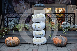 Halloween design home. Street decoration thanksgiving. Cozy scary porch of the house with orange and white pumpkins in fall time.