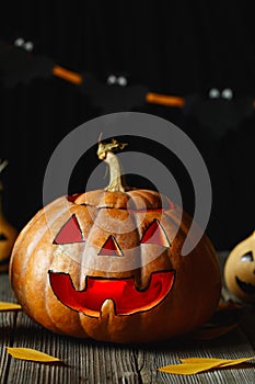 Halloween design with pumpkins. Horrible symbol of Halloween - Jack-o-lantern. Scary head of pumpkin with flame and a few small