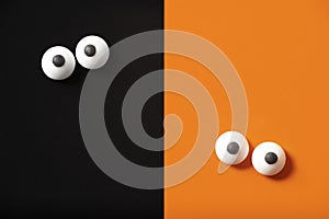 Halloween design, two pairs of eyes leaning out, orange and black background