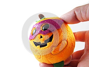 Halloween doll with fancy pink mask, orange pumpkin on hand