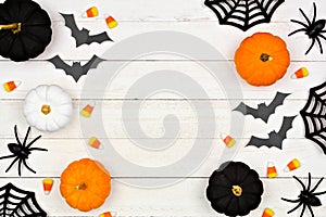 Halloween double side border with black, orange and white decor and candy over white wood