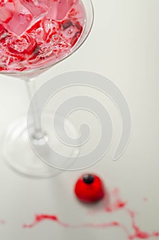 Halloween drink in a martini glass based on vodka, cream liqueur and grenadine with an edible decorative element in the shape of