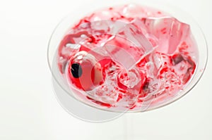 Halloween drink in a martini glass based on vodka, cream liqueur and grenadine with an edible decorative element in the shape of