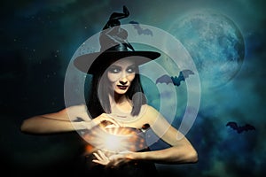 Halloween fantasy. Scary witch conjuring photo