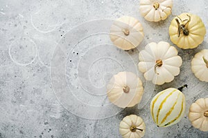 Halloween festive autumn background. Autumn decor from pumpkins, berries, maple leaves and chestnuts on old rustic stone tiles