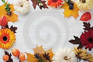 Halloween festive autumn background. Autumn decor from pumpkins, berries, maple leaves and chestnuts on old rustic white wooden