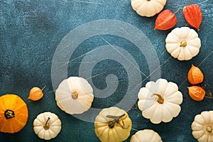 Halloween festive autumn background. Autumn decor from pumpkins, berries, maple leaves and chestnuts on old scratched blue