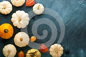 Halloween festive autumn background. Autumn decor from pumpkins, berries, maple leaves and chestnuts on old scratched blue backgro