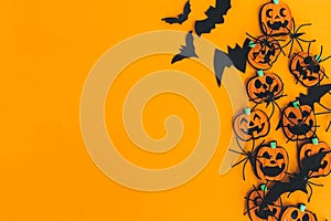 Halloween flat lay. Modern pumpkins jack o lantern, spiders, bats border on orange background with space for text. Season`s