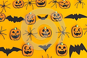 Halloween flat lay. Modern pumpkins jack o lantern, spiders, bats layout on orange background. Happy Halloween. Halloween
