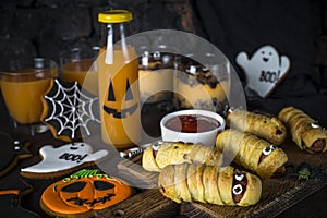 Halloween food assortment - sasage mummies, pumpkin dessert, gin