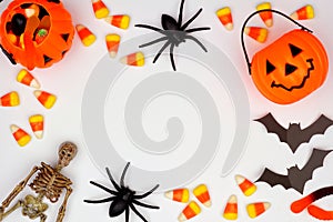 Halloween frame of scattered candy and decor over white