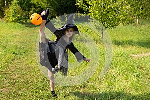 Halloween girl going to collect candy. Trick-or-treating. Guising. Jack-o-lantern. Child in carnival costume witch