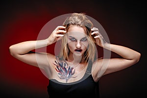 Halloween girl vampire with red eyes red lips and red background