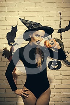 Halloween girl in witch hat and black bodysuit