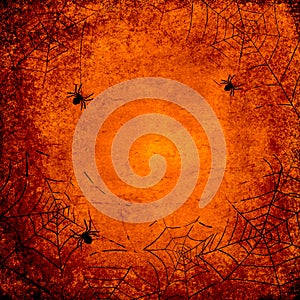Halloween grunge orange background with silhouettes of spider webs