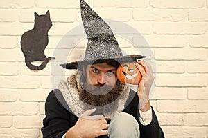 Halloween hipster with pumpkin and black cat symbol on wall