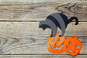 Halloween holiday background with black cat and Jack-oâ€™-Lantern cut paper on old boards.
