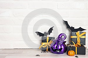 Halloween holiday background with gifts and decorations against a white brick wall