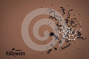 Halloween holiday background with party decorations from bats and spider webs with confetti and ribbon top view. Greeting card